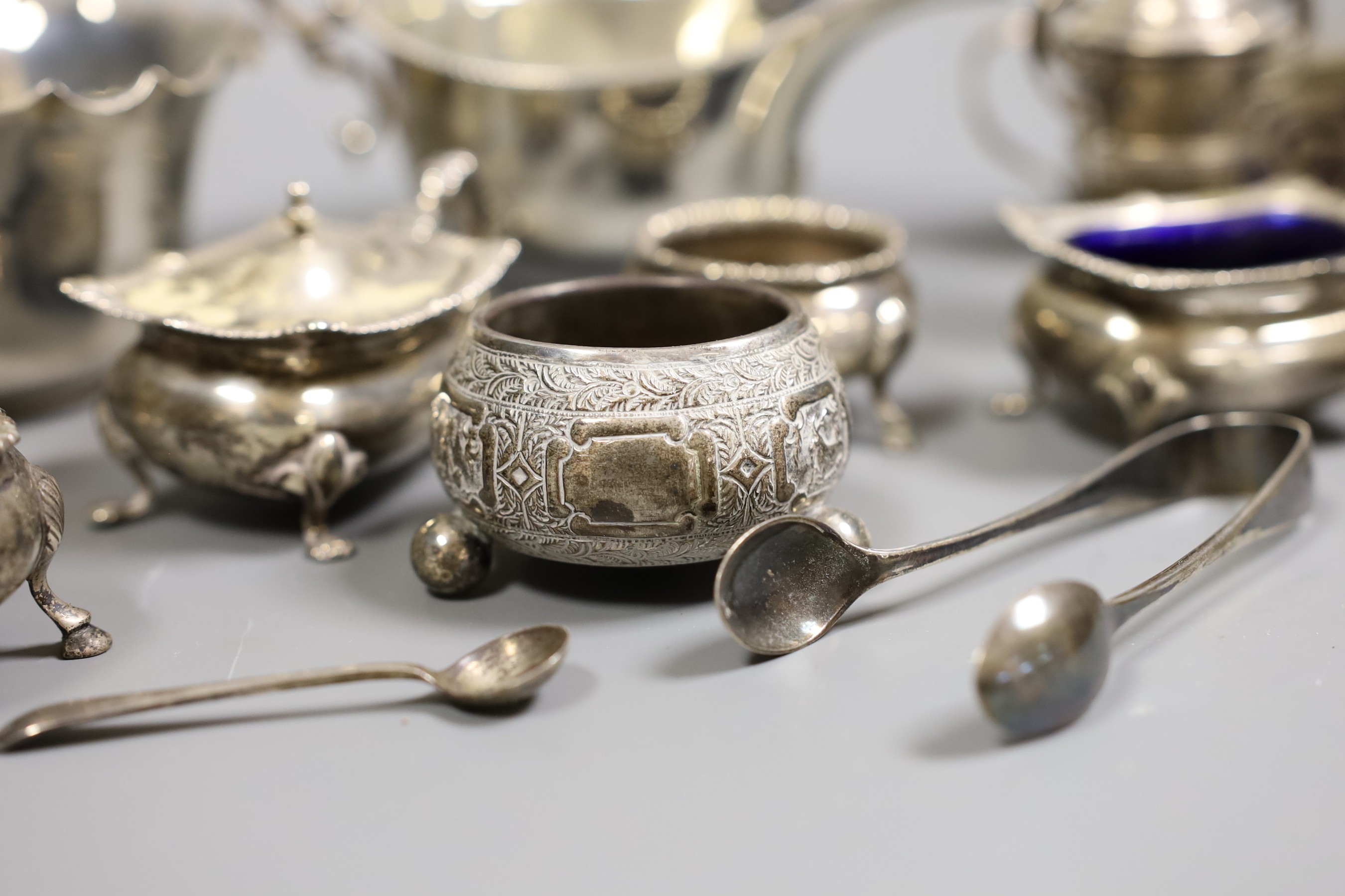 A small collection of mixed silver to include cased cutlery, a ladle, sauceboats, condiments, etc.